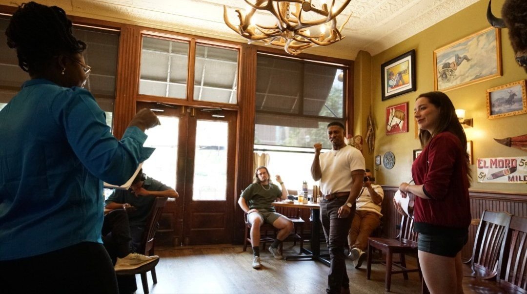Reine directing cast members in the Between Two Lives coffee shop set