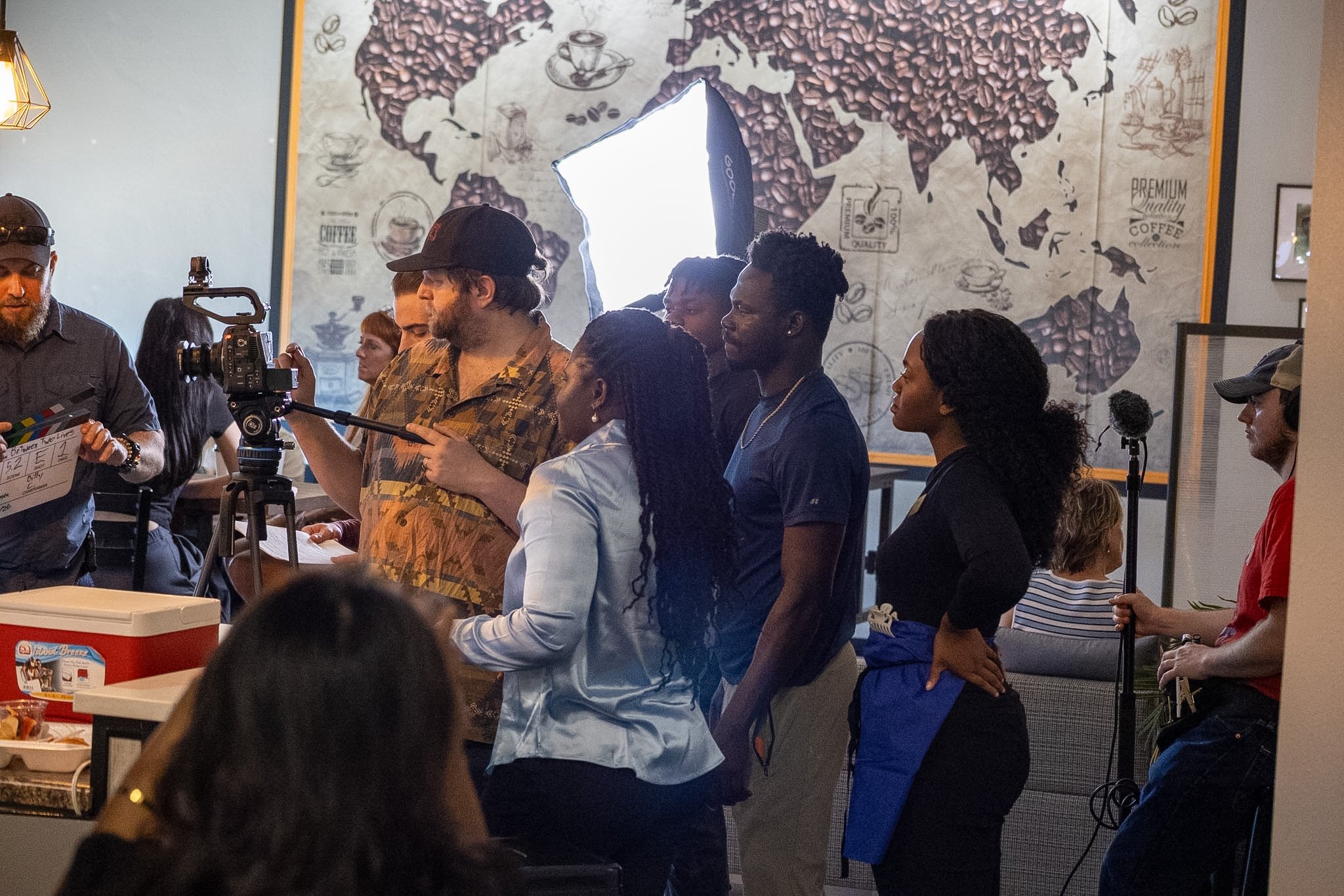 Between Two Lives clapboard held in front of the camera as cast and crew gather