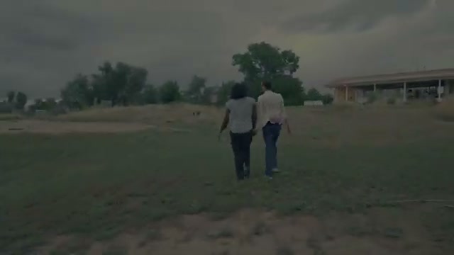 Two people walking together in a field in Grace In Disguise